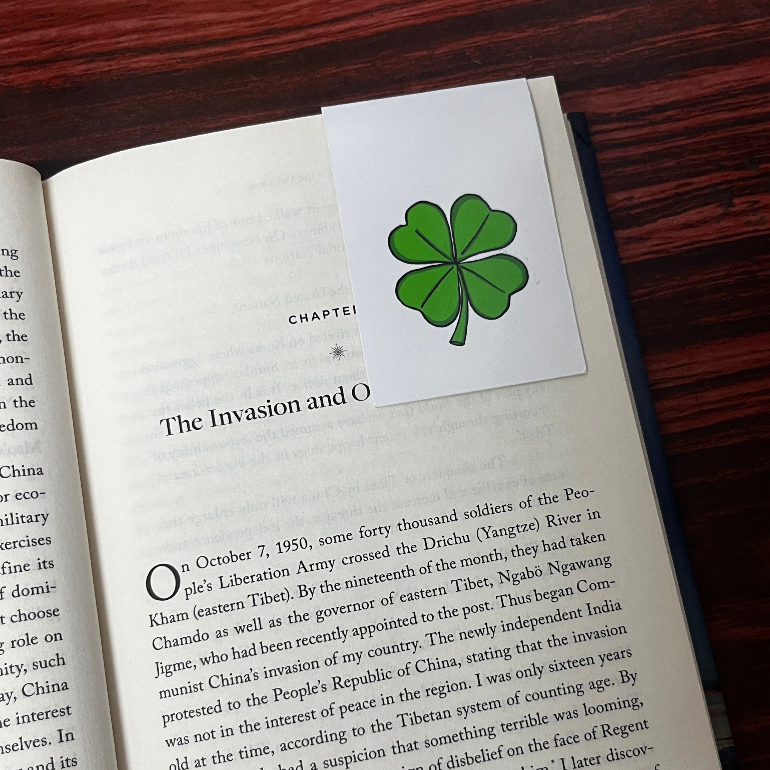 Book open to a page with a four-leaf clover magnetic bookmark