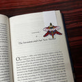 Open book with a magnetic bookmark on a wooden surface