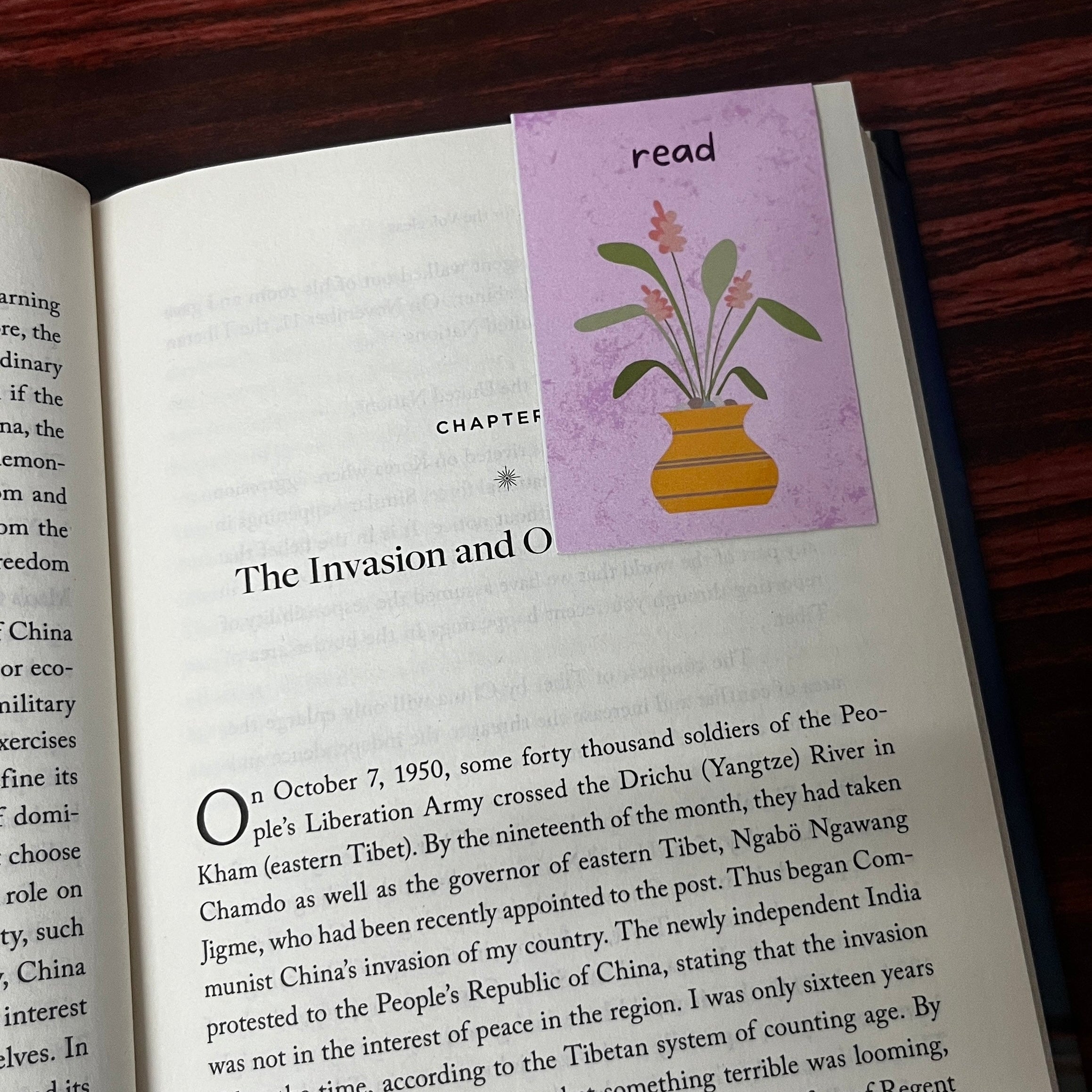 Open book with a decorative sticker on a wooden surface