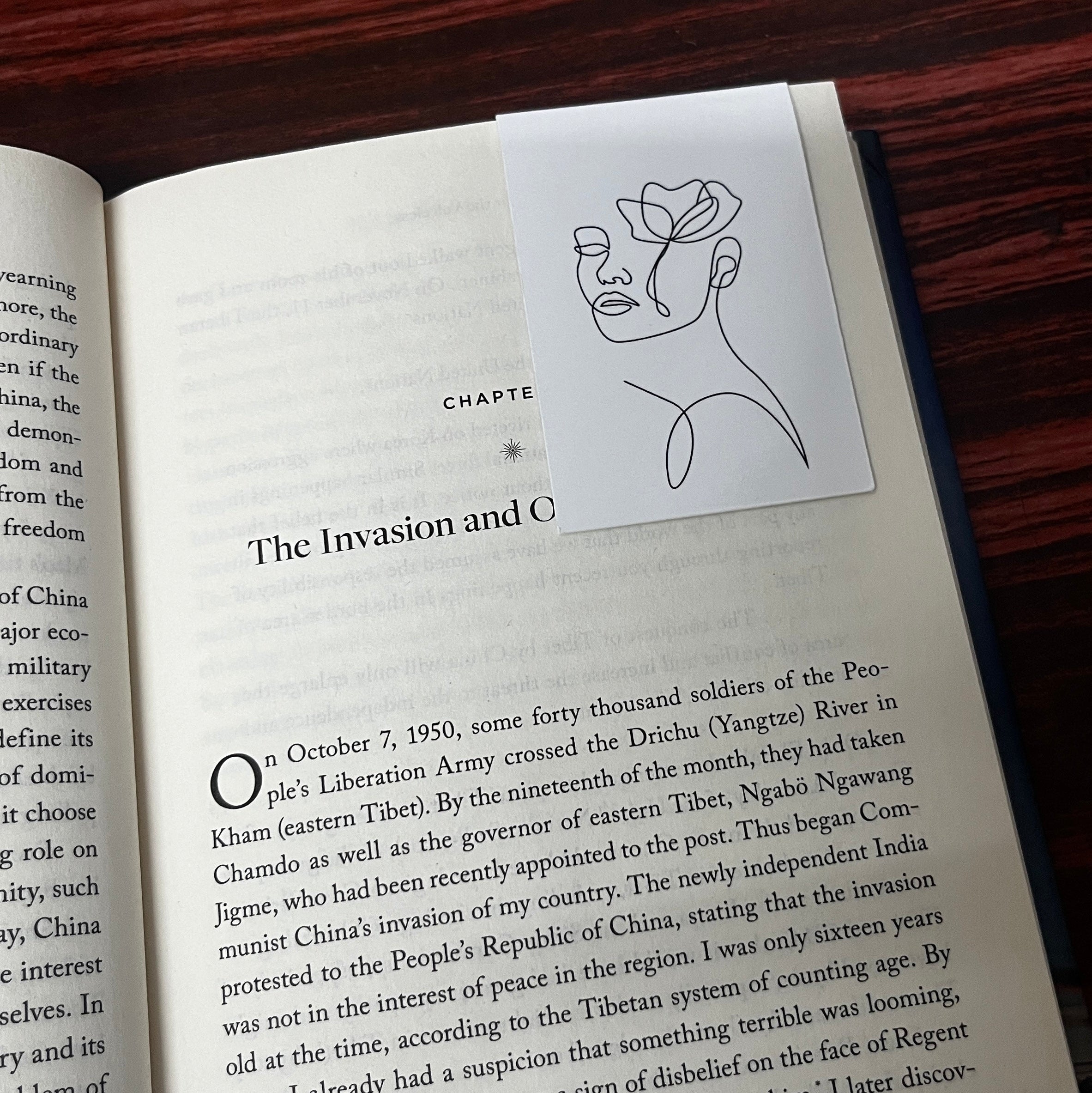 Book with a bookmark featuring a line drawing of a woman
