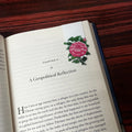 Open book with a floral illustration on a wooden surface