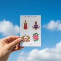 Hand holding a card with traditional designs against a blue background